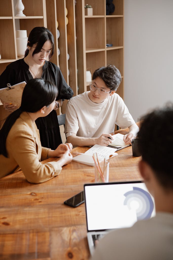 Group of professionals in a business meeting discussing projects in a modern office.