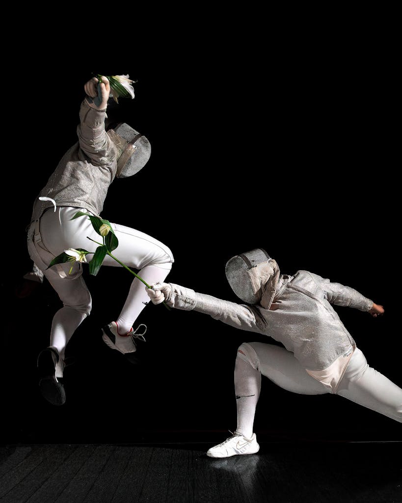Two fencers engage in a dramatic duel using flowers instead of swords.
